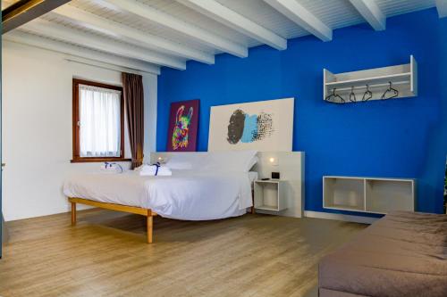 Un dormitorio azul con una cama grande y una pared azul en Le Tofane, vivi la bellezza di Belluno - Genziana, en Sòis