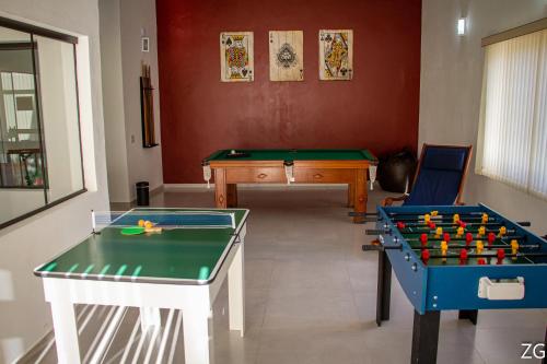 two pool tables in a living room with a table at Pousada Pé na Terra in Brotas