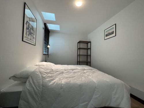 une chambre avec un lit blanc et une fenêtre dans l'établissement Charmant T2 climatisé dans monument historique à Rochefort, proche centre-ville - FR-1-246B-14, à Rochefort