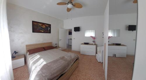 een slaapkamer met een bed en een plafondventilator bij Appartamenti Da Michela in Cavallino-Treporti
