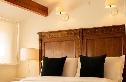 una camera con letto e testiera in legno di Panorama Guest House ad Alghero