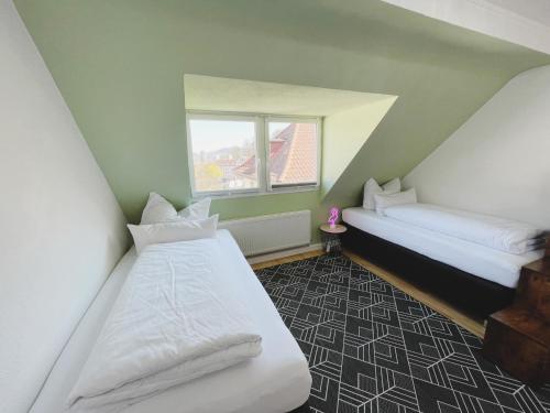 - 2 lits dans une chambre avec fenêtre dans l'établissement City Apartment Alt Saarbrücken, à Sarrebruck