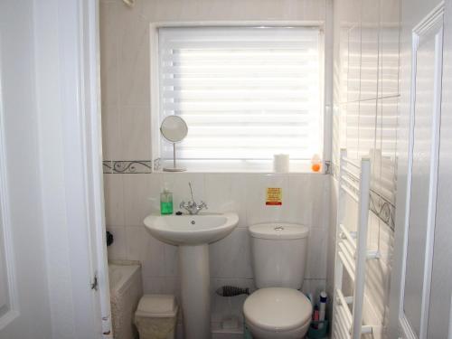 a bathroom with a sink and a toilet and a window at Sandy Creek Cottage - E5349a in Anderby