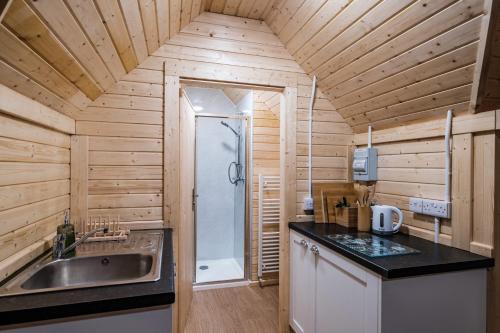 a small kitchen with a sink and a shower at Cairngorm Bothies in Aboyne