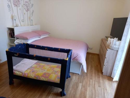 a small bedroom with a bed and a wooden floor at Ossola Bella la tua casa in Domodossola