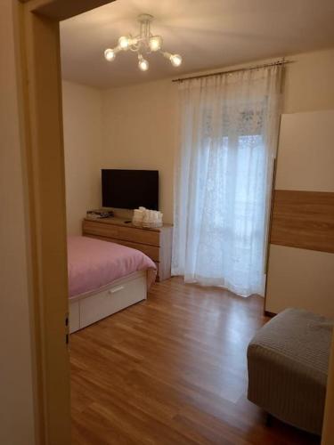 a room with a bedroom with a bed and a television at Ossola Bella la tua casa in Domodossola