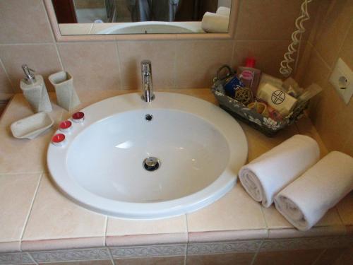 a sink in a bathroom with towels and a mirror at Villa Margherita Suite & charme in Pula