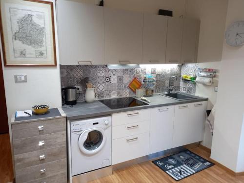 a kitchen with a sink and a washing machine at Ossola Bella la tua casa in Domodossola