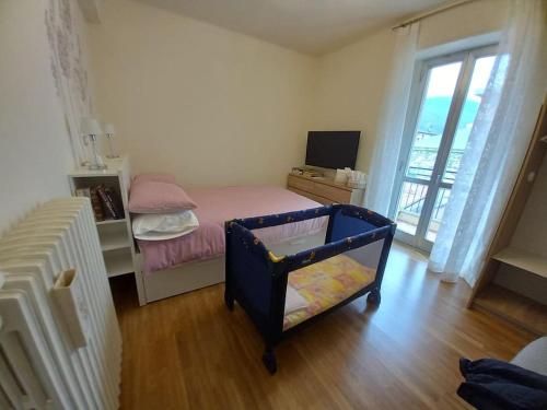 a small bedroom with a bed and a television at Ossola Bella la tua casa in Domodossola