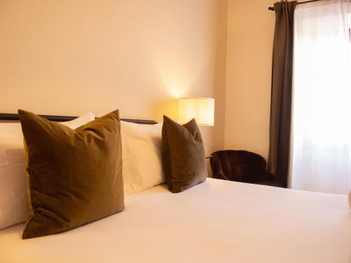 a bedroom with a bed with pillows and a window at Panorama Guest House in Alghero