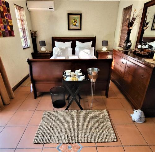 ein Schlafzimmer mit einem Bett mit einem Tisch und einem Bettsenalsenalsenalsenalsenal in der Unterkunft Guesthouse Private Room with Garden and Pool in Gaborone