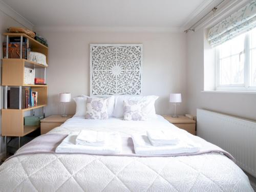 馬梅斯伯里的住宿－Historic Malmesbury - Delightful home with parking，一间卧室配有一张带两盏灯的大型白色床。