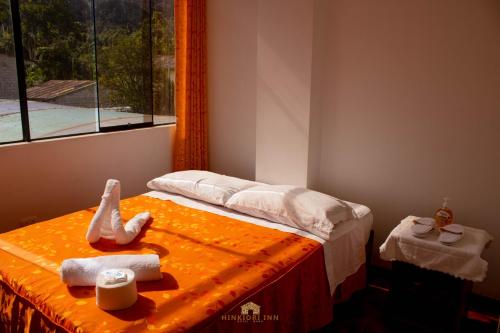 ein Schlafzimmer mit einem Bett mit Handtüchern und einem Fenster in der Unterkunft Hinkiori Inn - Hotel Manu in Pillcopata