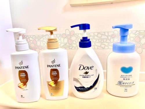 three bottles of laundry detergents on a bathroom counter at お子様連れ&動物好き大歓迎！産みたての卵を収穫体験できる宿 in Nanjo