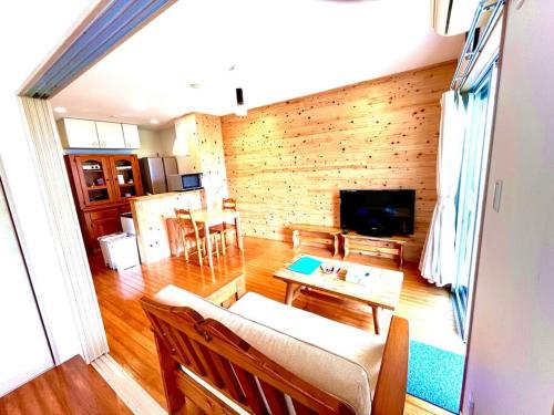 a living room with a couch and a table at お子様連れ&動物好き大歓迎！産みたての卵を収穫体験できる宿 in Nanjo