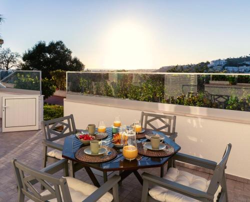 una mesa con comida y velas en el balcón en Apartamento Sunset on the Sea, en Albufeira