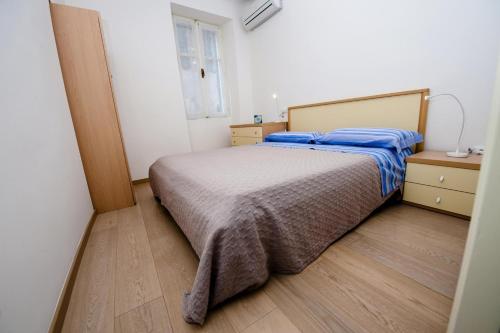a bedroom with a bed and a wooden floor at Apartment Al Porto in Rovinj