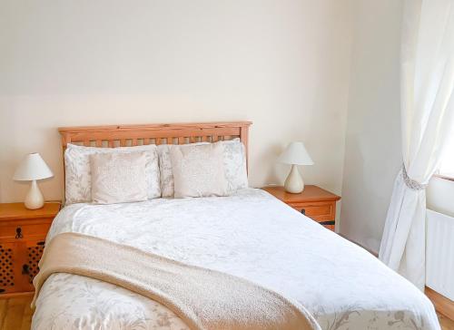 a bedroom with a white bed with two lamps at Clydagh Lodge by Trident Holiday Homes in Castlebar