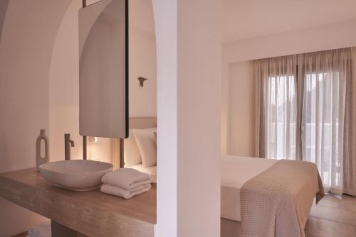 1 dormitorio con 1 cama y lavamanos en la encimera en Isida Andros, en Agios Petros