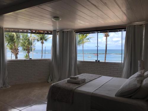 a bedroom with a bed with a view of the ocean at Pousada Verdes Mares in Praia do Frances