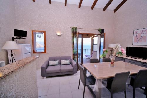 un salon avec une table à manger et un canapé dans l'établissement Aria, à Cargèse