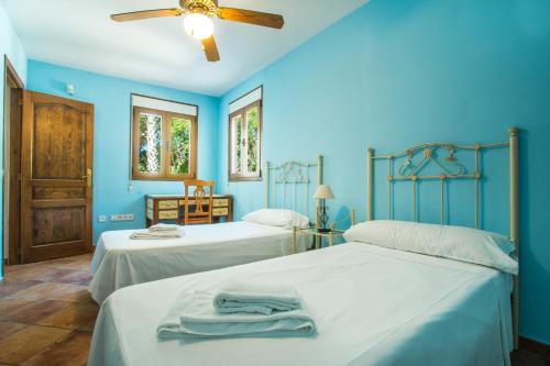 two beds in a room with blue walls at Villa Cintya - PlusHolidays in Ifach