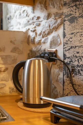 a metal tea kettle sitting on top of a table at Stefanis Guest House in Krásion