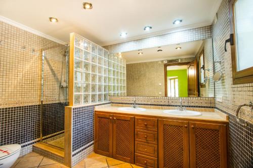 a bathroom with two sinks and a shower at Villa Cintya - PlusHolidays in Ifach