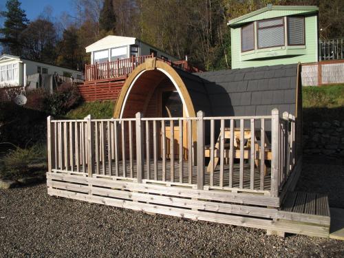 a wooden fence in front of a dog house at Corriefodly Holiday Park in Blairgowrie