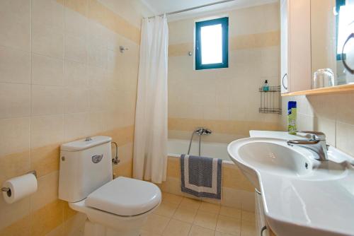 a bathroom with a white toilet and a sink at THERETRA KIOTARI VILLAS in Gennadi