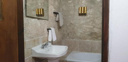 y baño con lavabo, aseo y espejo. en Galileo Cottage House (BREAKBOOKING CY), en Parekklisha