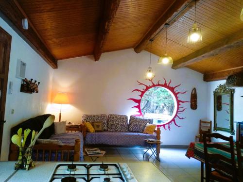 una sala de estar con sofá y un sol en la pared en Chambre Indépendante Piscine, Parc, Cuisine..., en Brézilhac