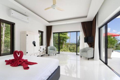 una camera da letto con un letto con un nastro rosso sopra di paradise sea view infinity Pool Villa Chaweng Koh Samui a Chaweng Noi Beach