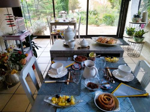 a table with breakfast food on it in a room at Chambre Indépendante Piscine, Parc, Cuisine... in Brézilhac
