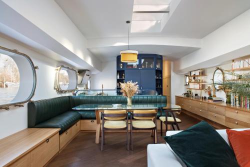 a dining room with a green couch and a table at Escale Sur Seine in Paris