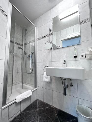 a white bathroom with a sink and a shower at Hotel Bilger Eck in Konstanz