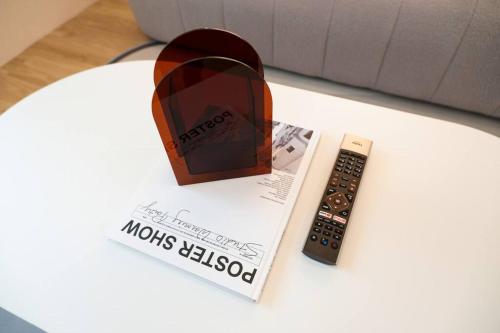 a remote control sitting on top of a table next to a book at 2BR minimal mu-ji style 130SQM ~ in Makkasan
