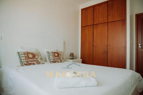 Una cama blanca con una toalla maccada. en Mareada by TonsdeVerde, en Apúlia