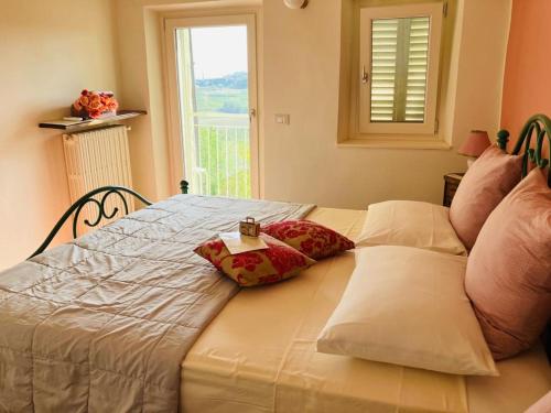 a bed with two pillows on it with a window at La Vite è Bella in Govone