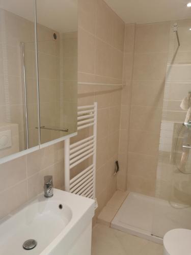 une salle de bain blanche avec une douche et un lavabo dans l'établissement JUAN LES PINS 2P Le Tropique, à Juan-les-Pins