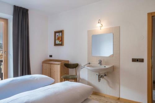 a hotel room with a bed and a sink at Adlerhorst Blaumeise in Santa Valpurga