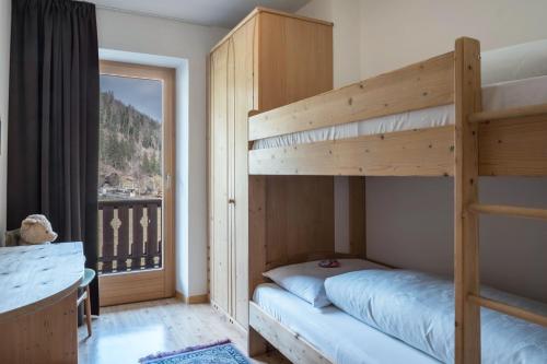 a bedroom with two bunk beds and a window at Adlerhorst Blaumeise in Santa Valpurga