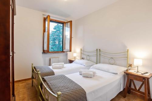 2 Einzelbetten in einem Zimmer mit Fenster in der Unterkunft Residenza di Campagna Montelleri in Vicchio