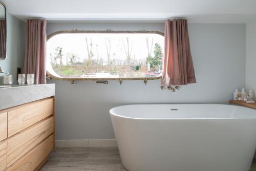 a bathroom with a tub and a window at Escale Sur Seine in Paris