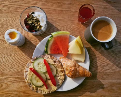 a plate of food with a sandwich and a cup of coffee at Comfort Hotel Eskilstuna in Eskilstuna