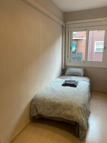 a small bedroom with a bed and a window at Cozy apartment at a great location! in Hospitalet de Llobregat