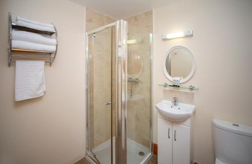 ein Bad mit einer Dusche, einem Waschbecken und einem Spiegel in der Unterkunft Redesdale Arms in Otterburn