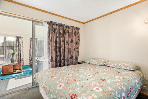 a bedroom with a bed and a window at Albert Town Bach - Wanaka Holiday Home in Wanaka