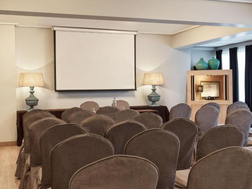 a conference room with chairs and a projection screen at Sea View Cityscape Hotel in Athens