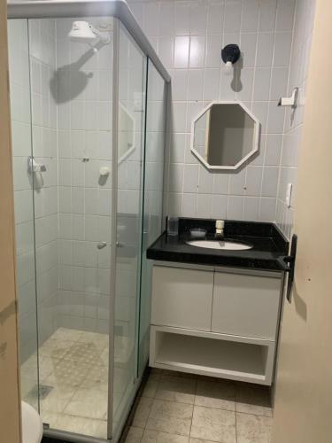 uma casa de banho com uma cabina de duche em vidro e um lavatório. em Hotel Victory flat em Cabedelo